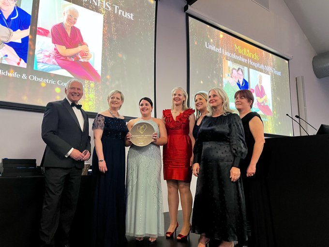 MUM2023 National Winners United Lincolnshire Hospitals NHS Trust collect their award from Master of Ceremonies Nick Owen at the Royal College of Obstetricians and Gynaecologists.
